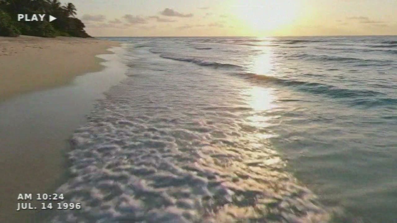 The same shoreline on tape: soft, the colour smeared sideways, PLAY in the corner and a 1996 date stamp