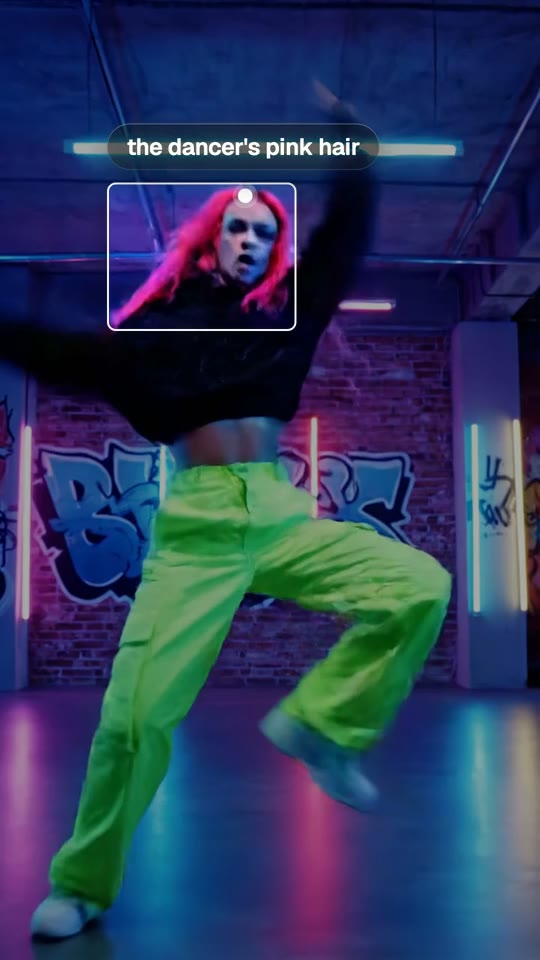 Find in Frame boxing a dancer's pink hair in a neon studio