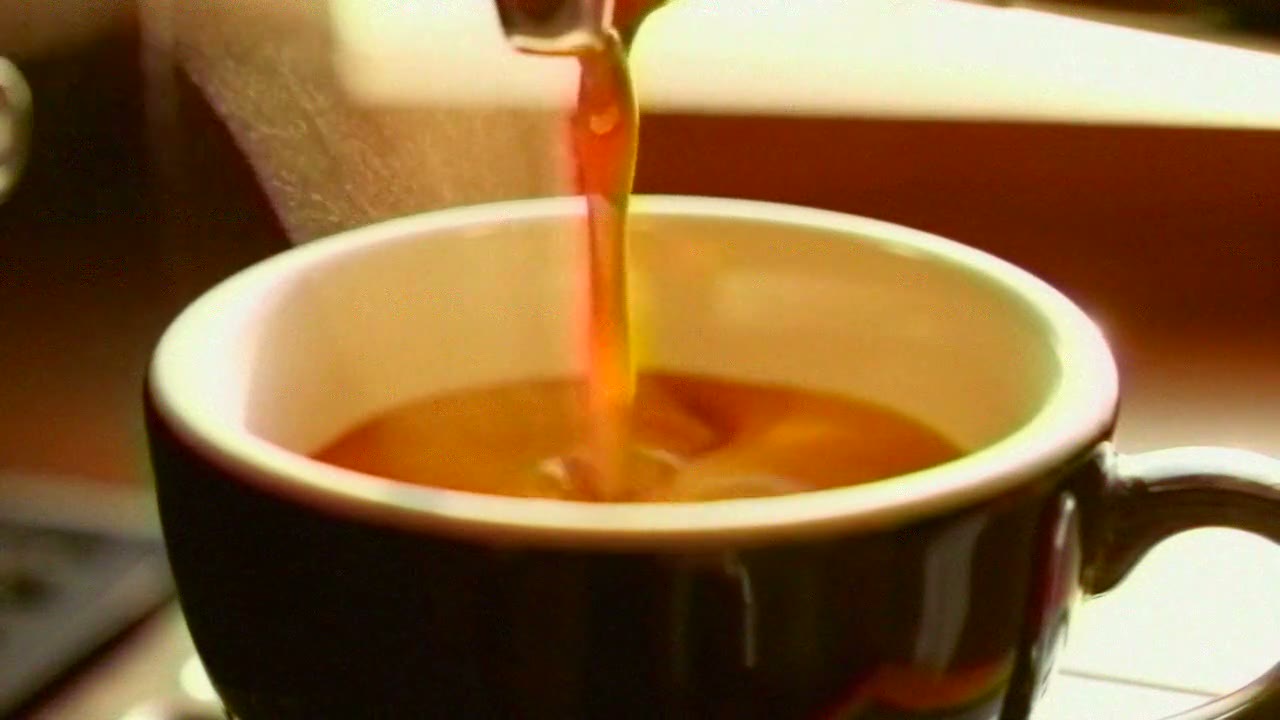 Espresso pouring into a cup, warm and soft with the colour bleeding