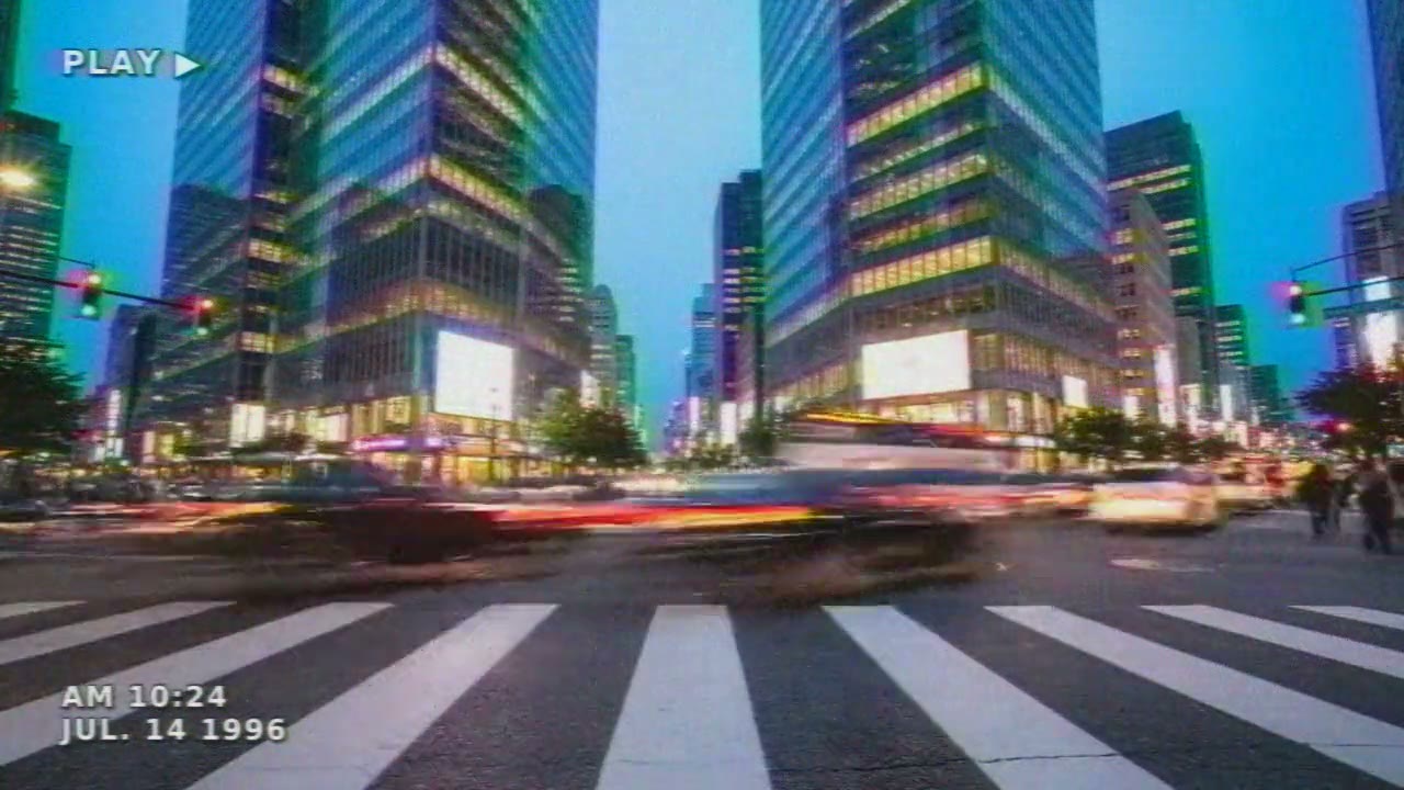 A city crosswalk at dusk on camcorder tape, with PLAY and a date stamp in the corners